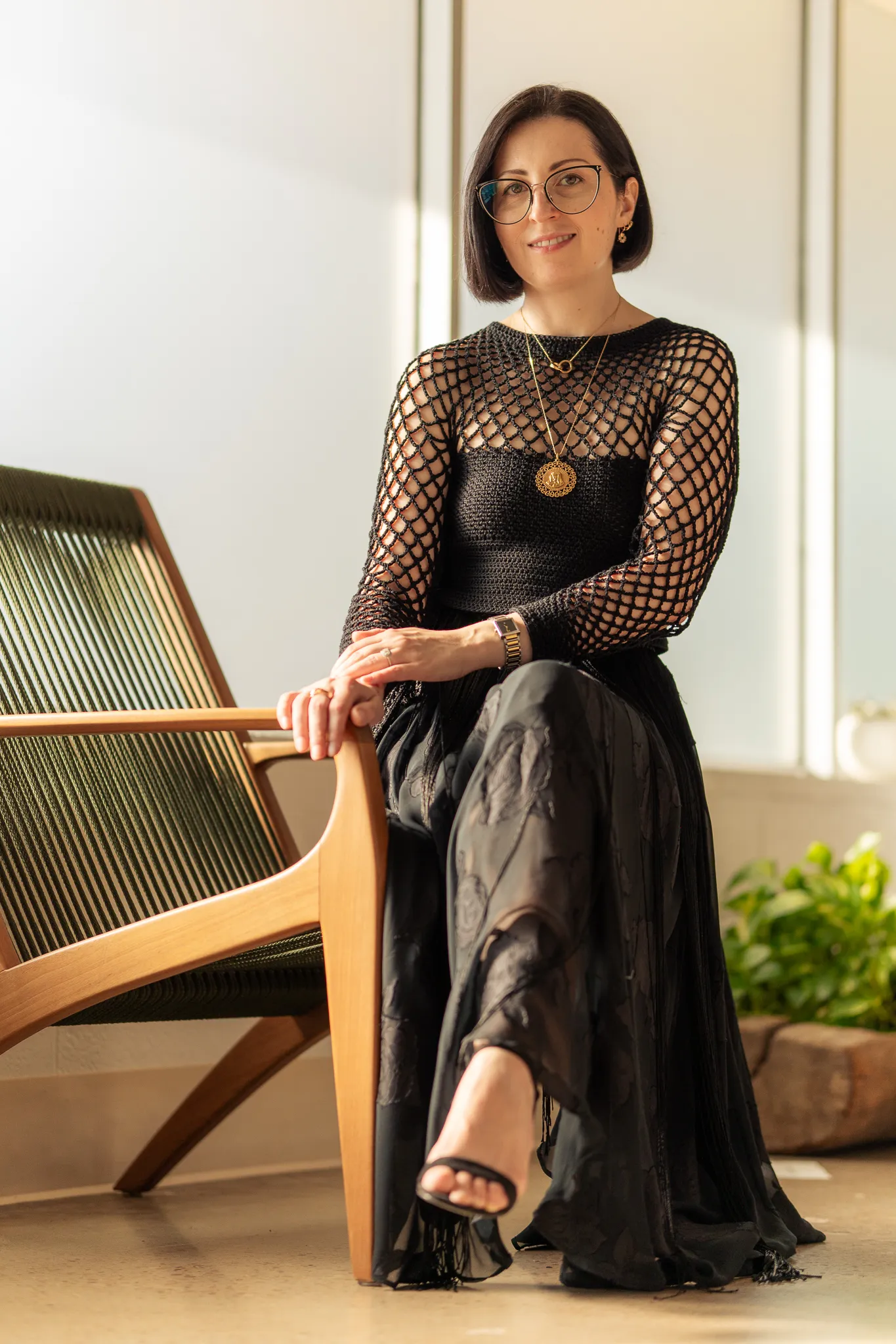 Portrait of Libby Tolm, founder and knitwear designer behind Looking Friday, wearing a black handcrafted open-knit top .