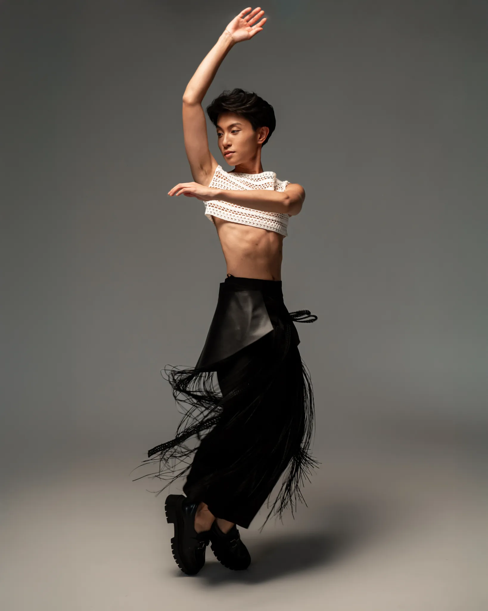 Model in Looking Friday black Silk Culottes layered with a sculptural Leather Belt, Fringe Crochet Belt, and cropped white Open Weave Crochet Overlay Top.